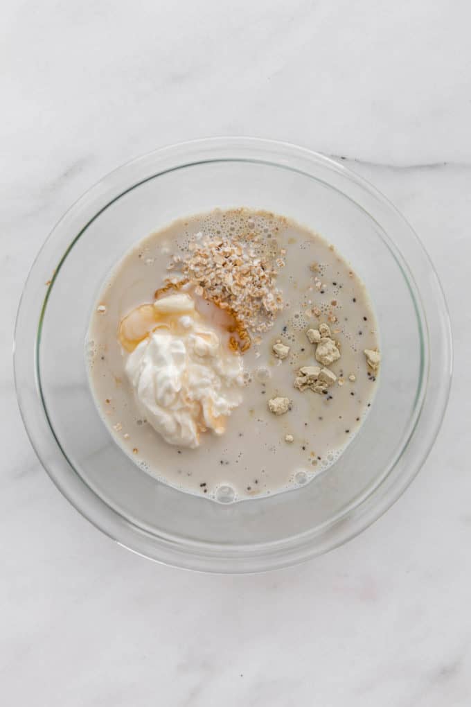 oat milk yogurt, oats and protein powder in a mixing bowl