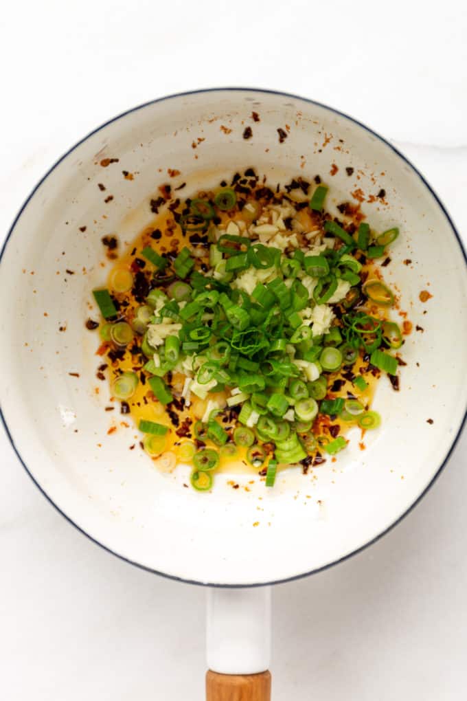 Scallions and chili oil in a white pot