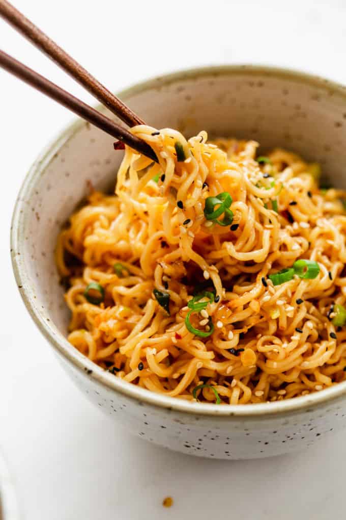 Chopsticks picking up ramen noodles from a bowl