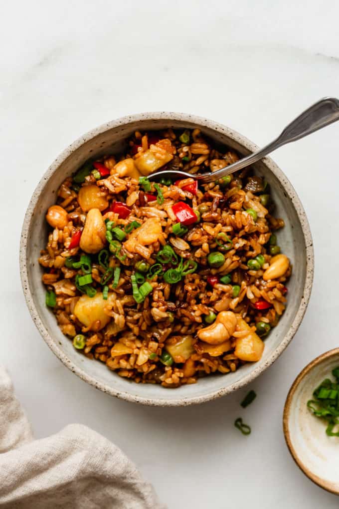 a bowl of pineapple fried rice with a spoon in it