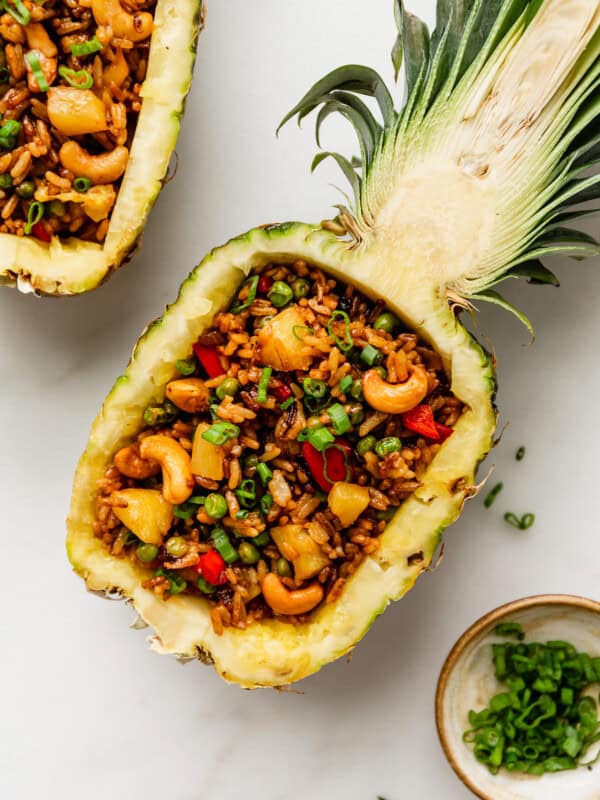 Thai pineapple fried rice in a pineapple bowl with green onions on top