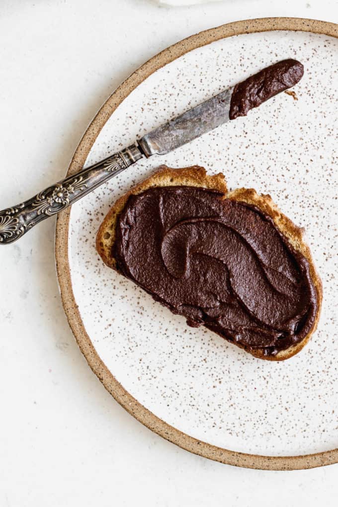 A piece of toast with vegan Nutella and a knife on the side