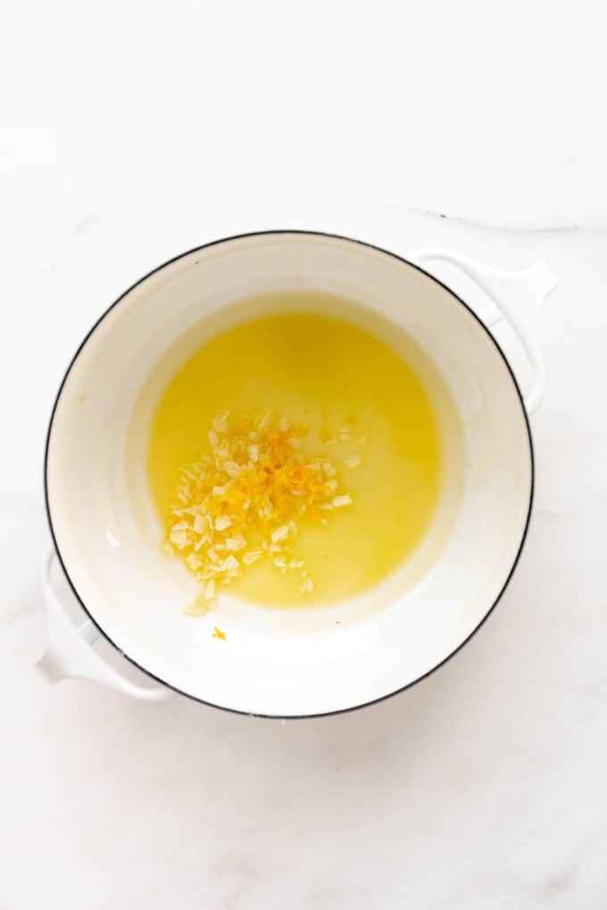 melted oil and butter with garlic and lemon zest in a white pot