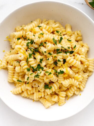 A bowl of lemon fusilli pasta topped with parsley