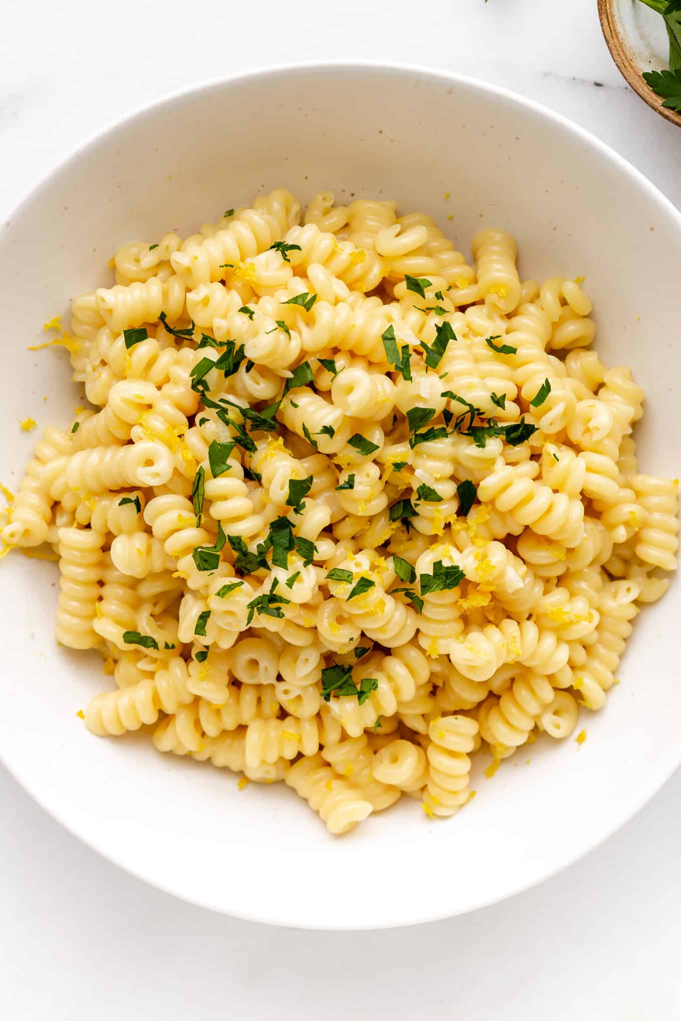 A bowl of lemon fusilli pasta topped with parsley