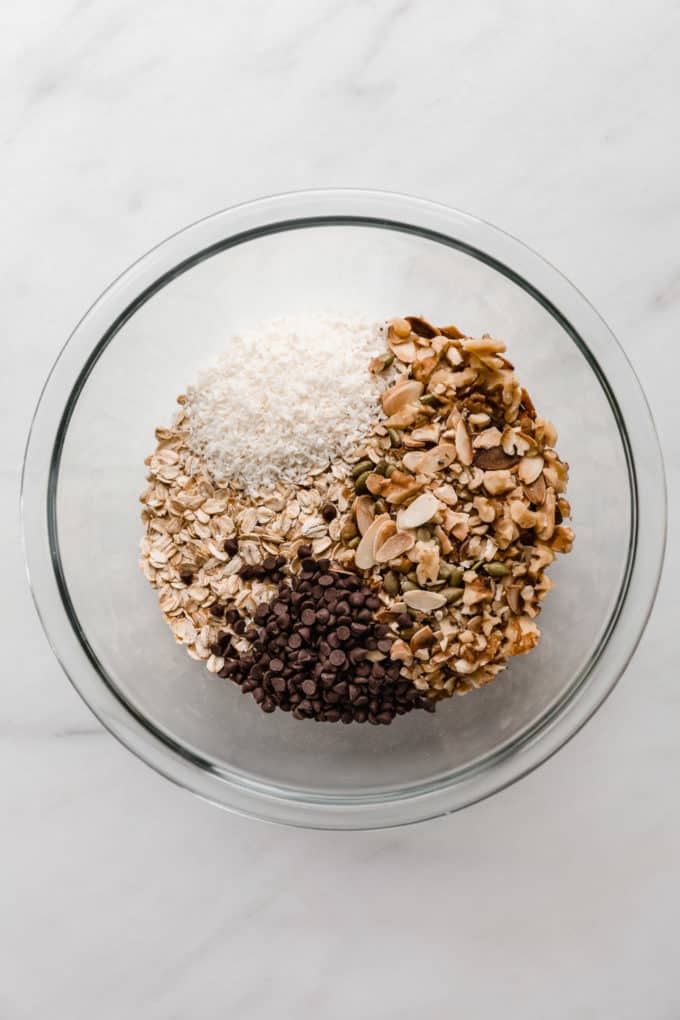 oats, nuts, coconut and chocolate chips in a mixing bowl
