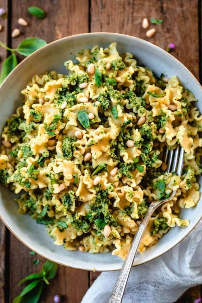 pasta with pesto in a bowl on a wood table