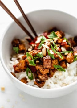 Kung pao tofu on rice in a white bowl