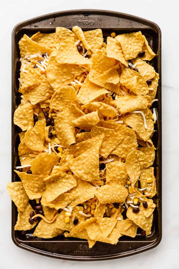 tortilla chips layered on a baking sheet