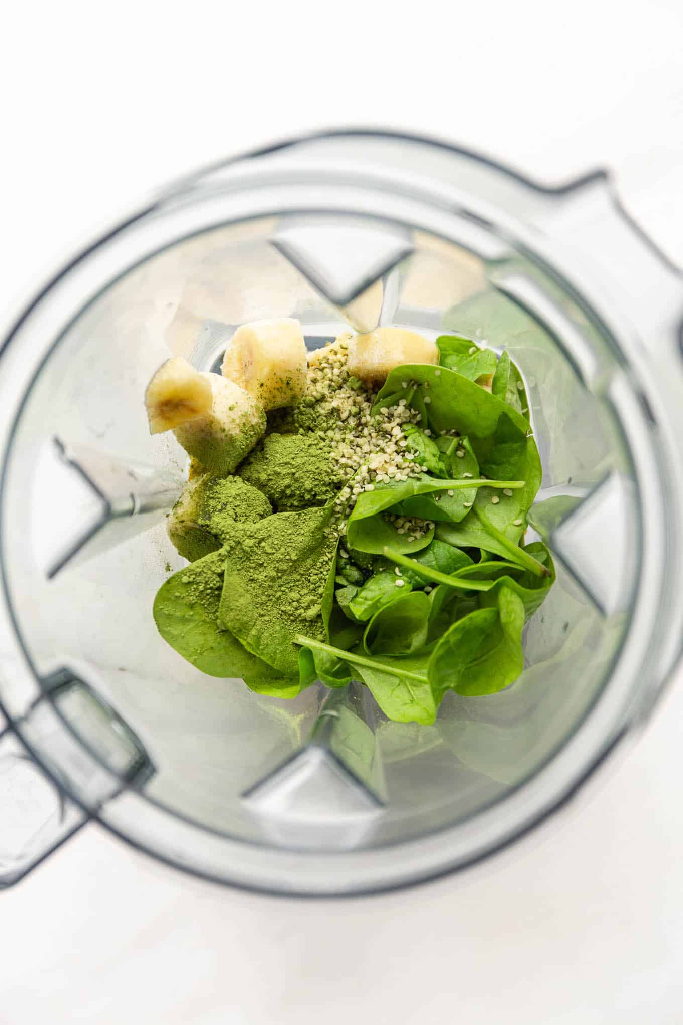 Spinach, matcha, banana and hemp seeds in a blender