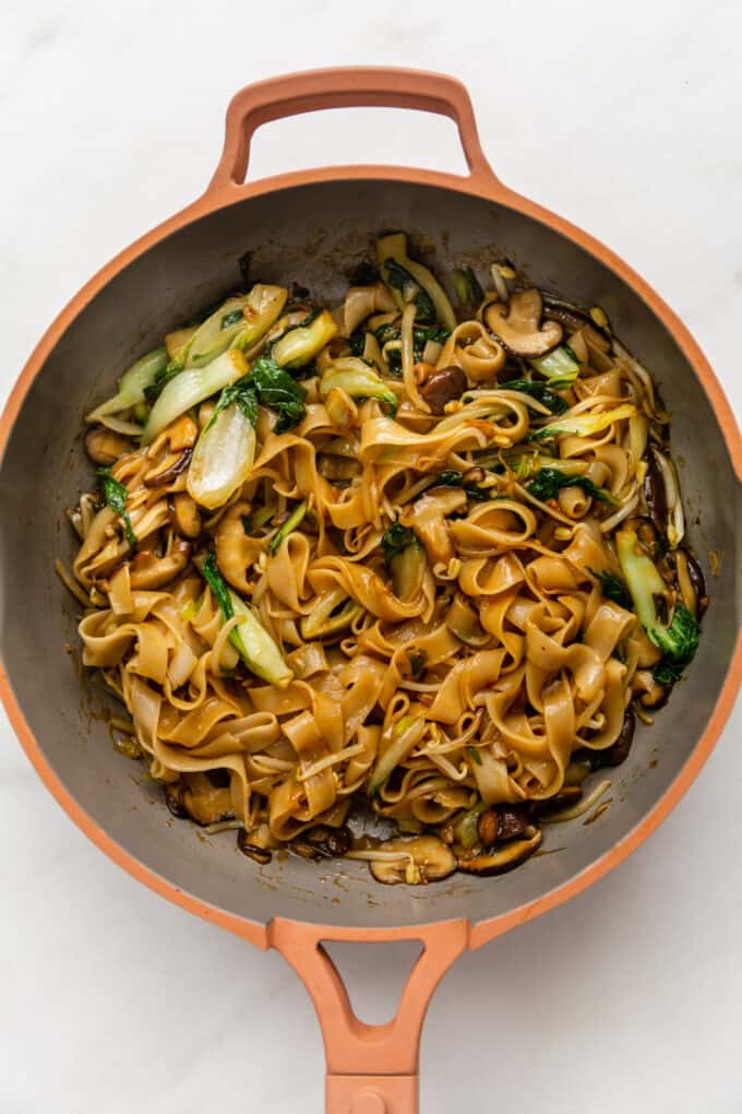 ho fun noodles stir fried in a pink pan
