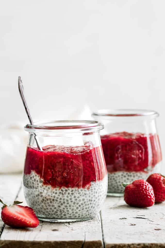 two jars of chia pudding topped with strawberry rhubarb compote