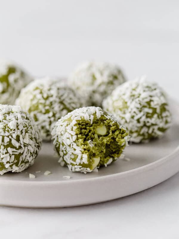 matcha balls coated in coconut on a white plate