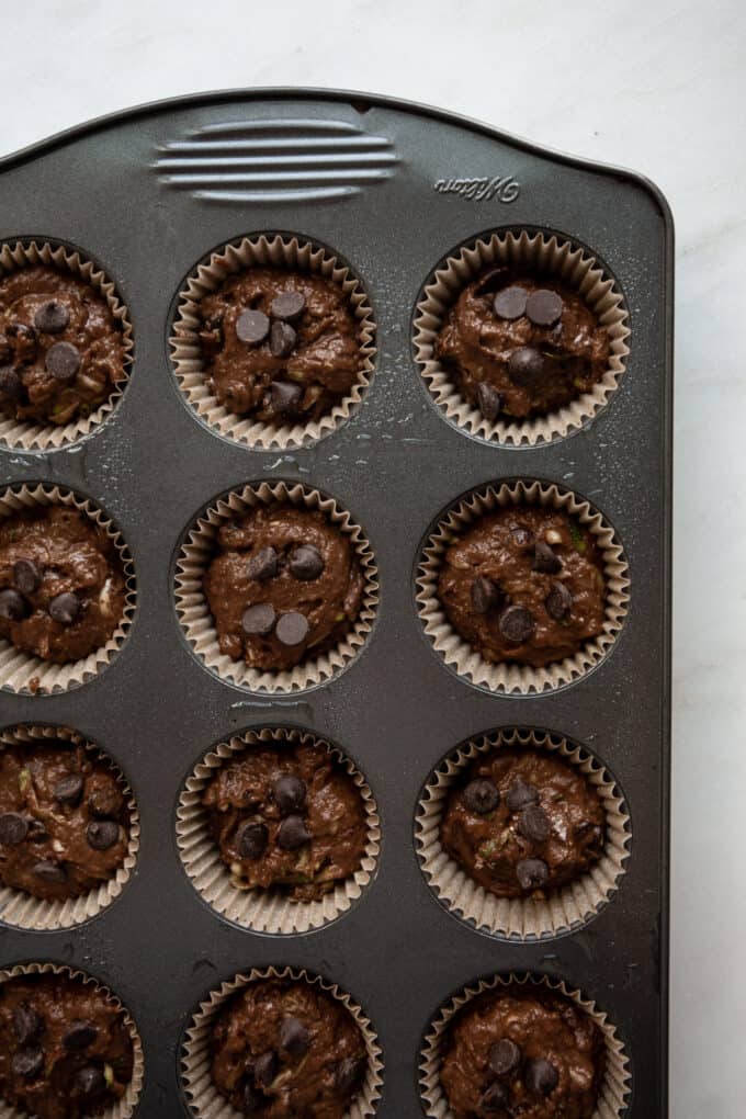 unbaked chocolate zucchini muffins in a muffin pan