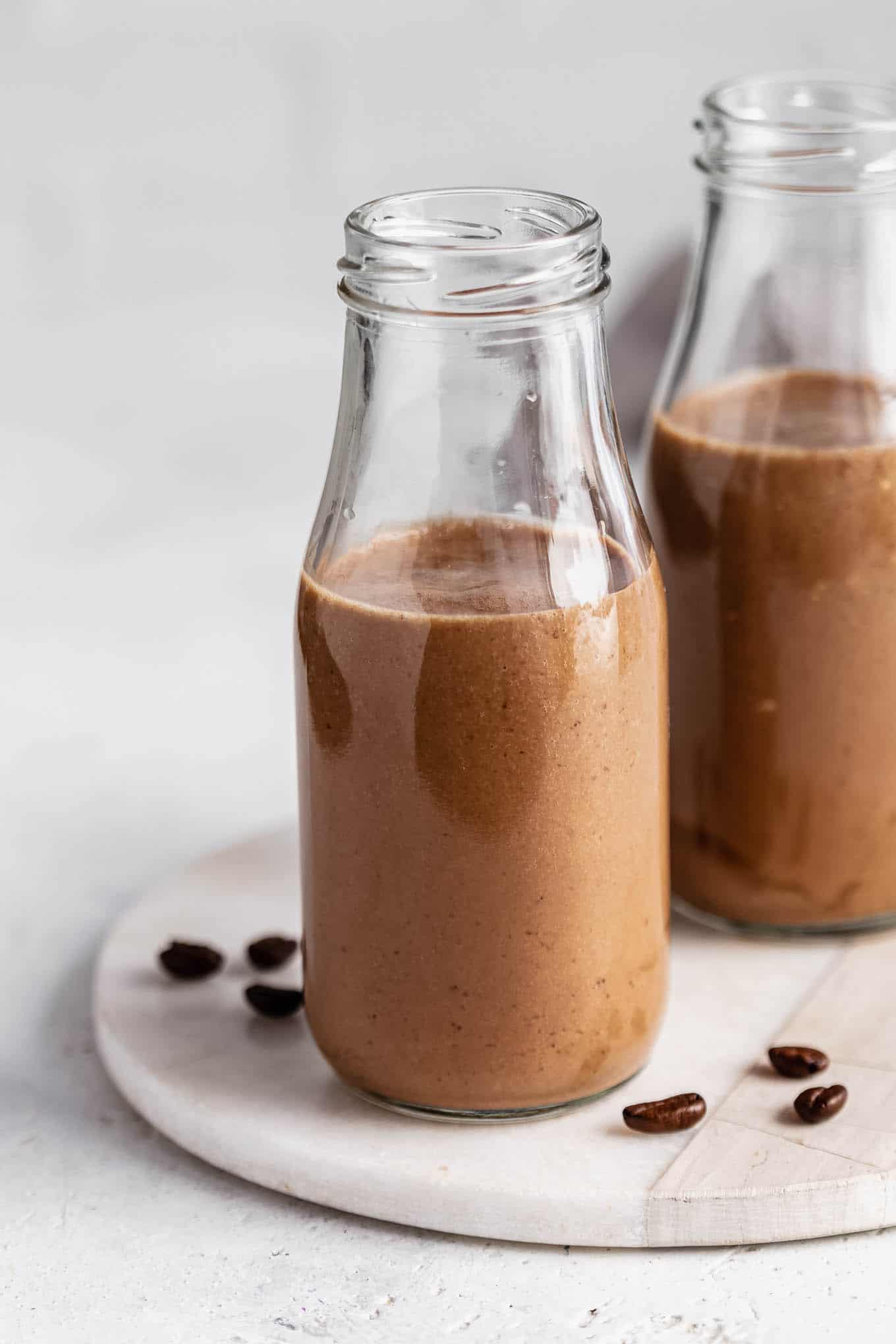 Two jars of coffee smoothie on a marble tray