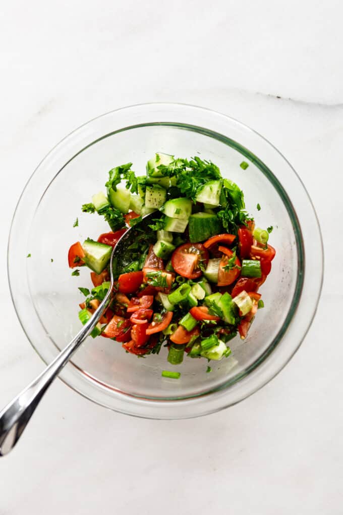 Israeli salad in a clear mixing bowl