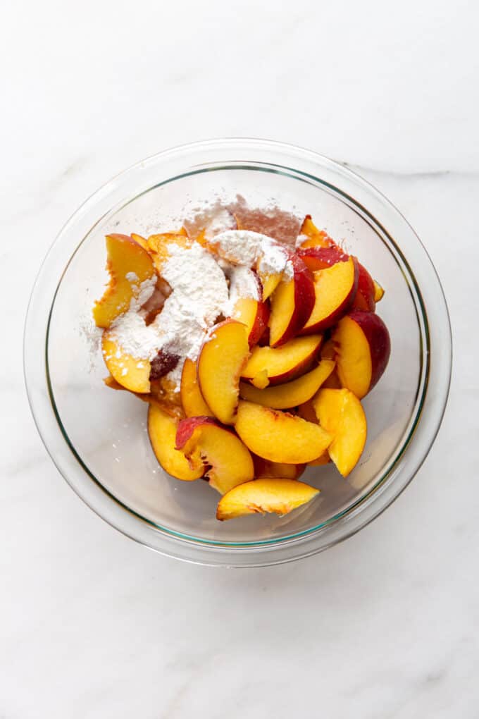 sliced peaches with cornstarch in a clear bowl