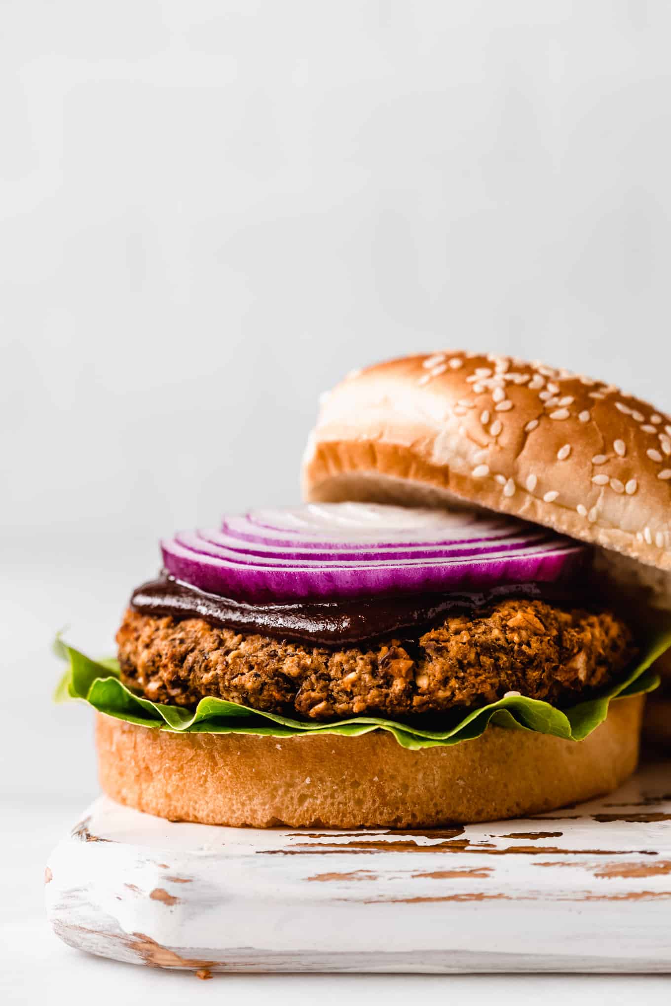 a lentil burger topped with bbq sauce and red onion