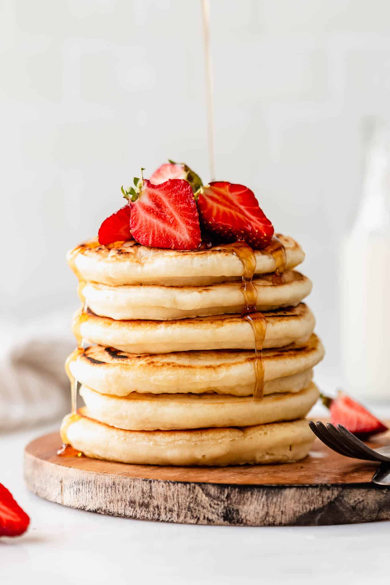 a stack of protein pancakes with maple syrup being poured on them