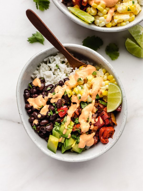 a vegan burrito bowl with rice and veggies topped with chipotle crema