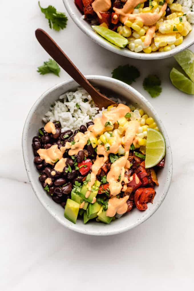 a vegan burrito bowl with rice and veggies topped with chipotle crema