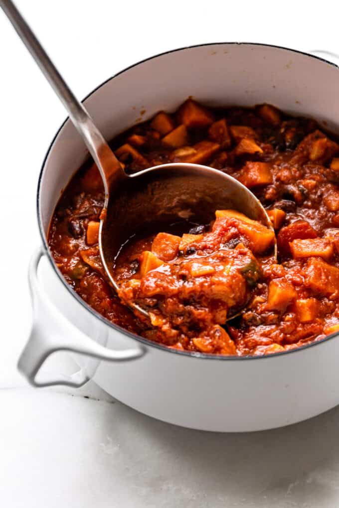 a ladle scooping sweet potato chili out of a pot