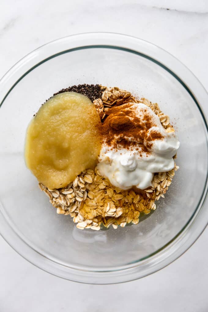 oats, chia seeds, maple syrup, yogurt and apple sauce in a clear bowl