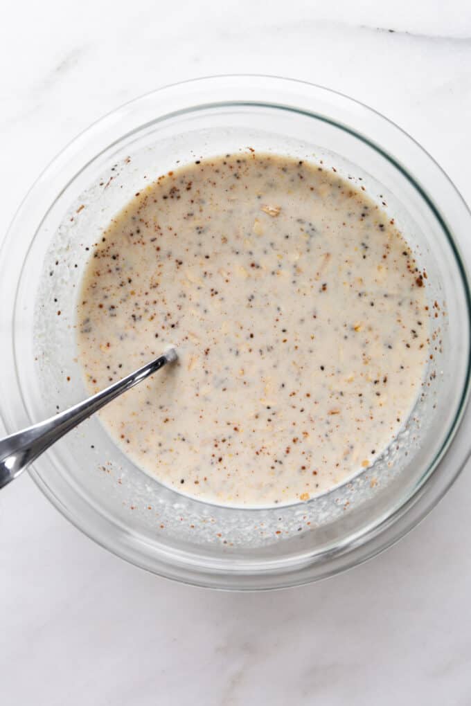 oats and chia seeds in almond milk in a clear bowl