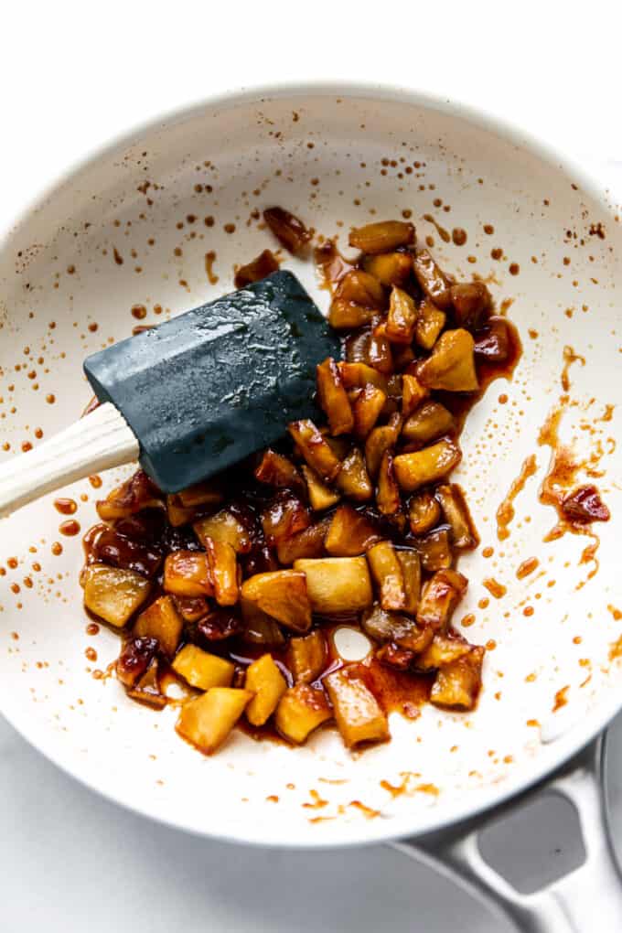 cooked cinnamon apples in a white pan