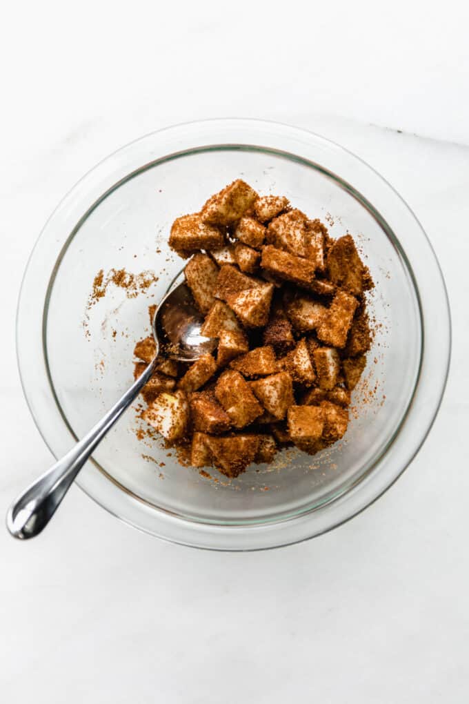 cut up cinnamon apples in a mixing bowl