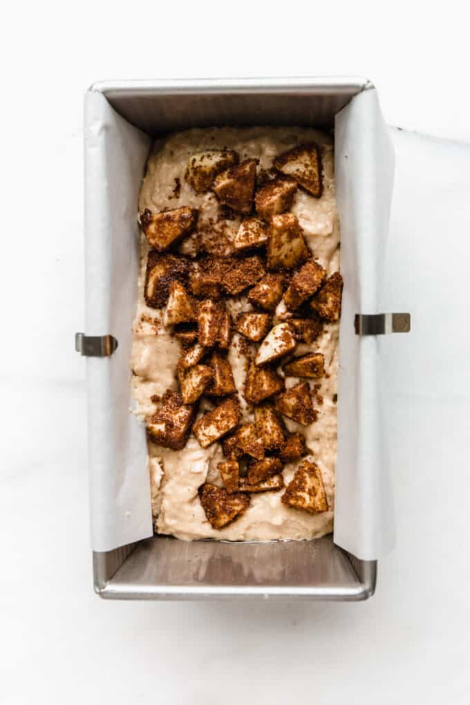 apple bread batter with cinnamon apples in a loaf pan