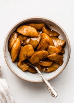 cinnamon apples in a small bowl with a spoon