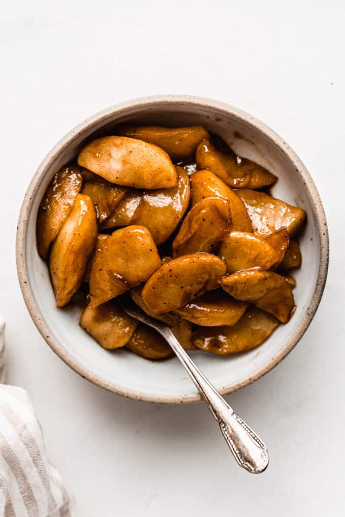 cinnamon apples in a small bowl with a spoon