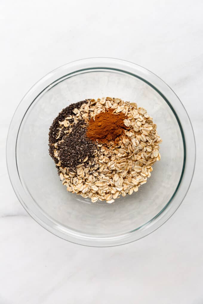 oats, chia seeds and cinnamon in a clear mixing bowl