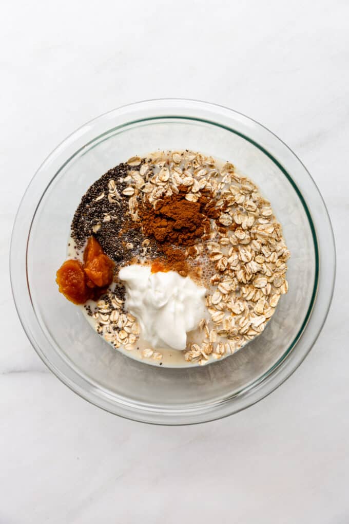 oats, almond milk, yogurt, pumpkin puree, chia seeds and cinnamon in a clear bowl
