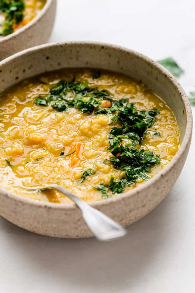 red lentil soup in a beige ceramic bowl