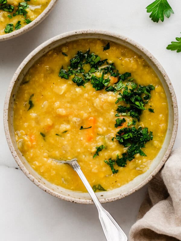 A bowl of red lentil soup topped with parsley