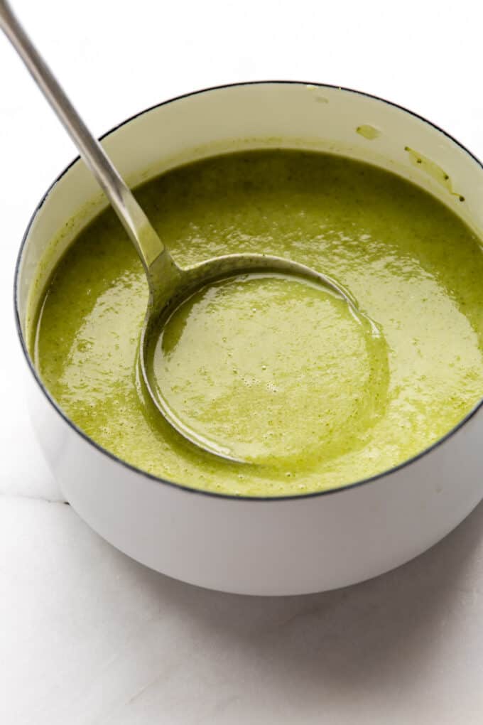 a ladle scooping broccoli potato soup from a pot