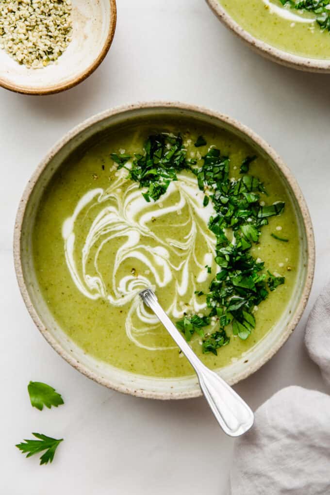 broccoli potato soup in a bowl with sour cream and parsley