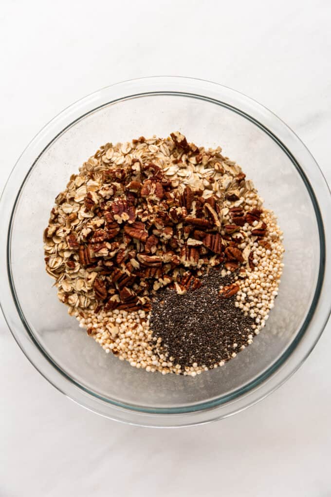 oats, pecans, puffed quinoa and chia seeds in a mixing bowl