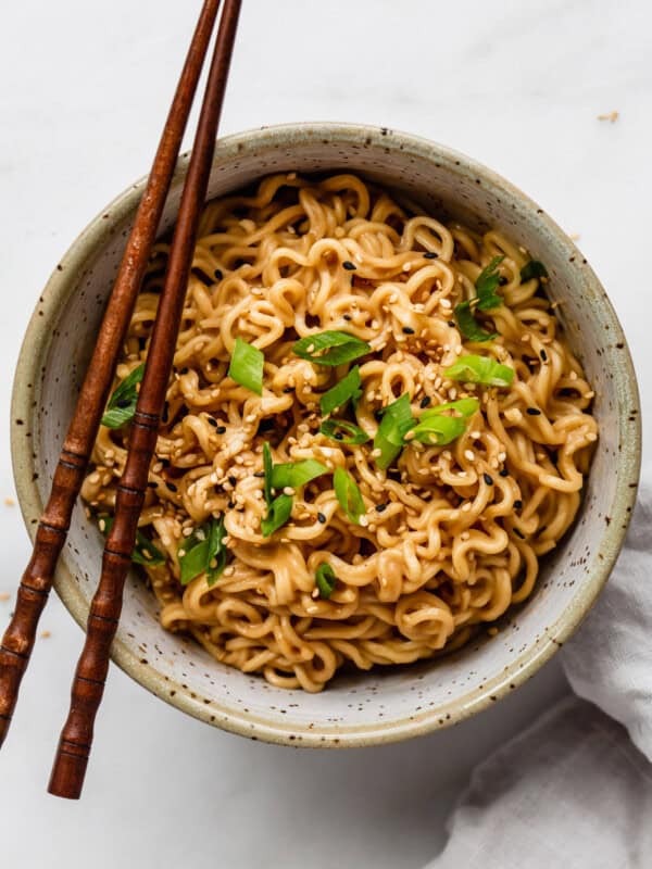 a bowl of peanut ramen noodles with chopsticks