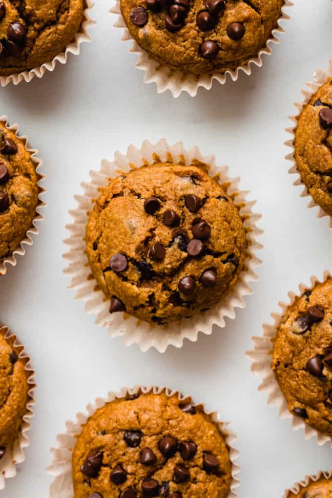 pumpkin muffins in muffin liners on a marble counter