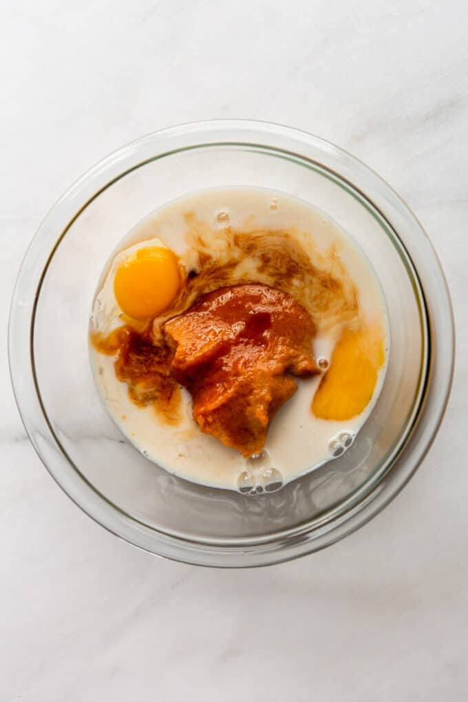 eggs, pumpkin puree and milk in a clear mixing bowl