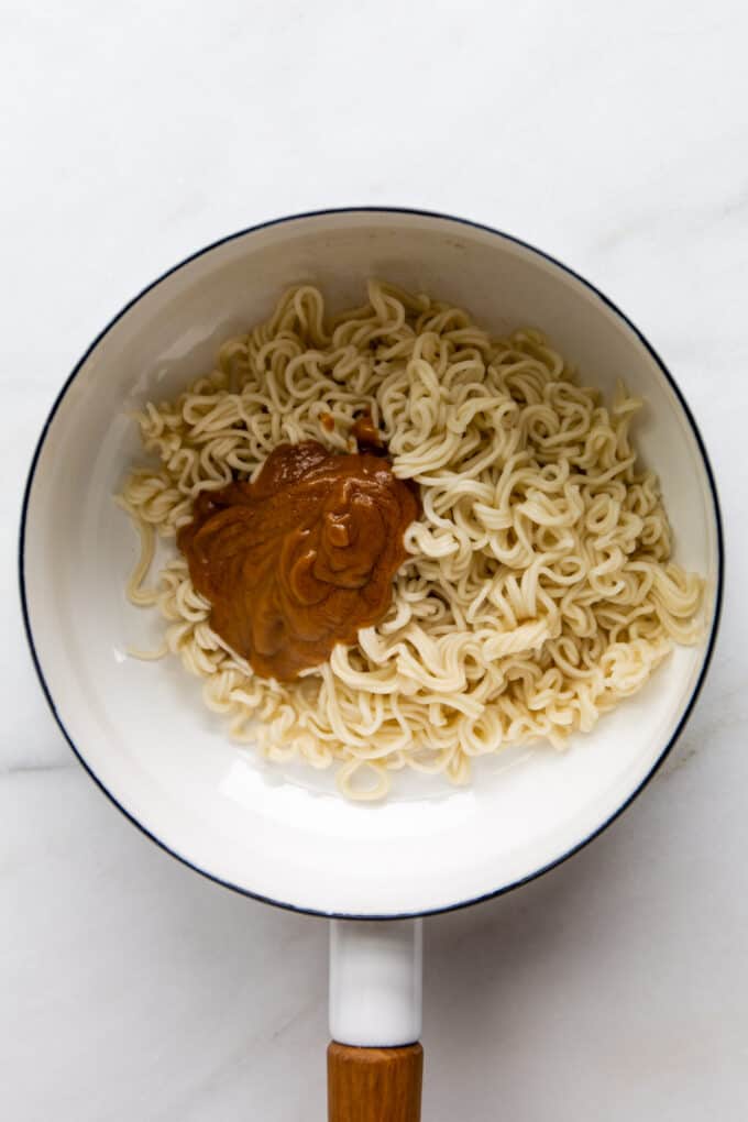 ramen noodles and peanut butter in a white pot
