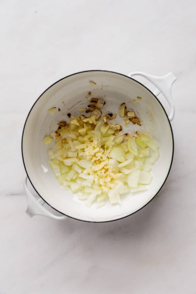 onions and garlic sautéed in a white pot