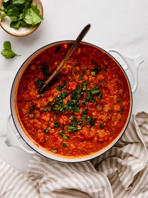 a pot of lentil chili with a beige striped napkin on the side
