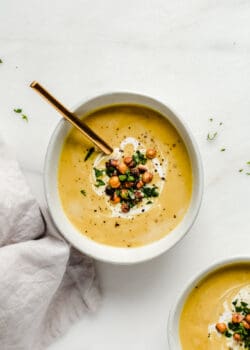 a bowl of curried cauliflower soup topped with crispy chickpeas and cilantro