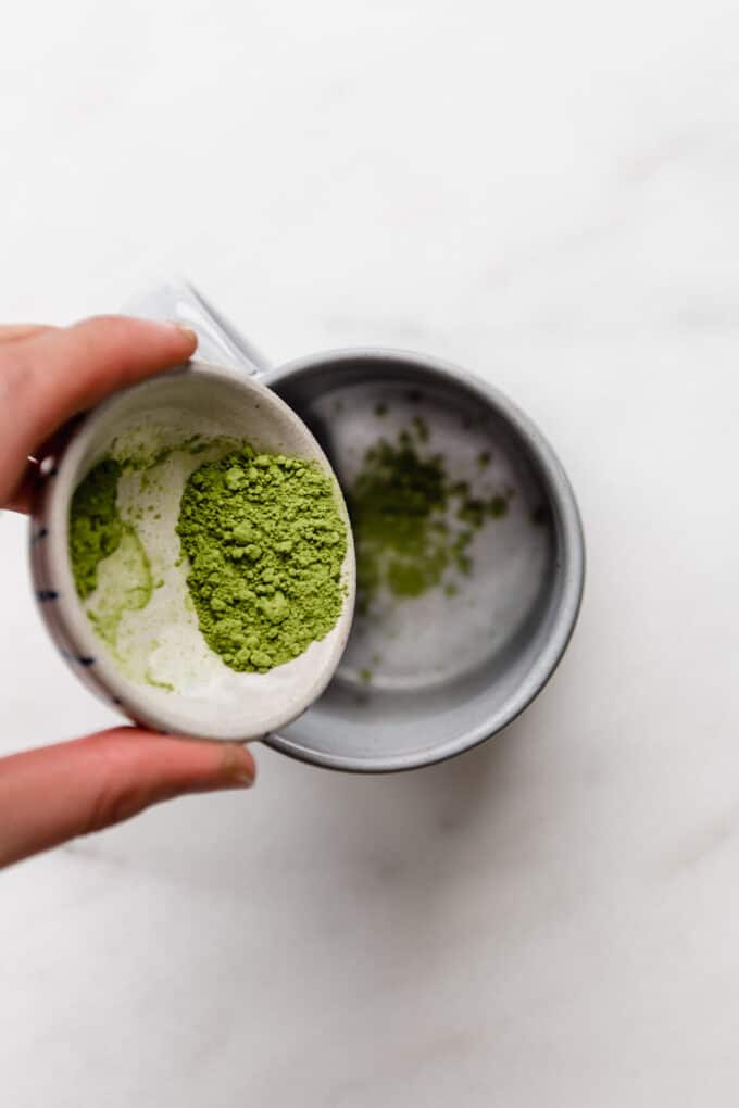 matcha powder being poured into a mug