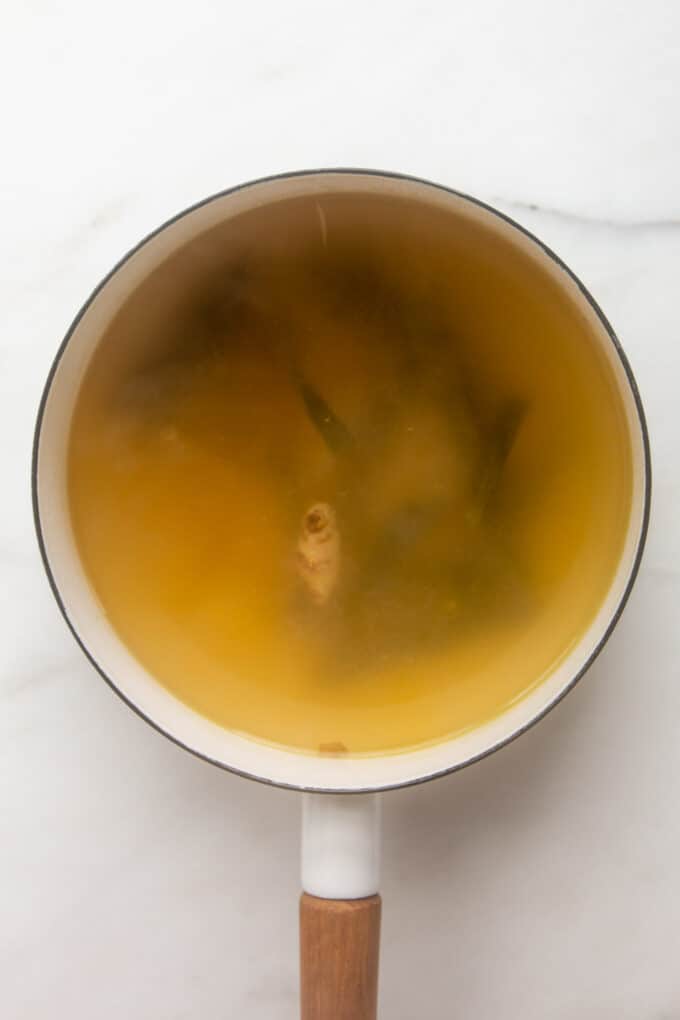 udon noodle soup broth in a white pot