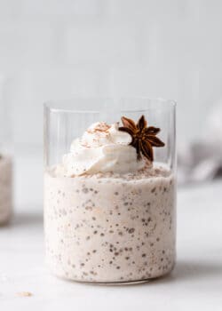 a cup of chai latte overnight oats topped with whipped cream
